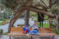 A girl with a child on a bench under the branches of a tree in Borjomi Park, on a rainy day. Georgia 2019 Royalty Free Stock Photo