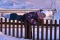 Girl child climbs the fence. Fun time is childhood. Winter sunny evening. Sunset