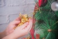 Girl, child decorates Christmas tree on white brick wall background