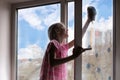 Girl child detergent with rag cleaning house, washing windows, springtime Royalty Free Stock Photo