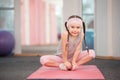 Girl child doing fitness exercises in health club, stretching in exercise