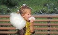 Girl child eating cotton candy in the park for a walk.