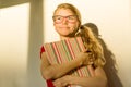 Girl child elementary school student wearing glasses is holding a textbook and dreamily smiling looking forward Royalty Free Stock Photo