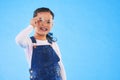 Girl child, glasses and frame in studio portrait for vision, health and eye care by blue background. Female kid, test Royalty Free Stock Photo