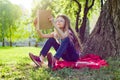 Girl child in glasses reading book in the park Royalty Free Stock Photo