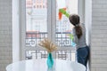 Girl child in gloves with spray detergent with rag cleaning windows Royalty Free Stock Photo