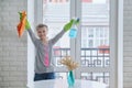 Girl child in gloves with spray detergent with rag cleaning windows Royalty Free Stock Photo