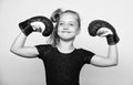 Girl child happy winner with boxing gloves posing on grey background. She feels as winner. Upbringing for leadership and