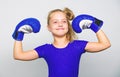 Girl child happy winner with boxing gloves posing on grey background. She feels as winner. Upbringing for leadership and