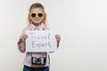 Girl child holding piece of paper with a word TRAVEL EXPERT. White bakgrounde, copy space