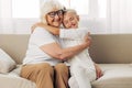 Girl child hugging grandmother couch granddaughter Royalty Free Stock Photo