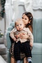 A girl child hugs her little brother while sitting on a chair