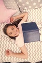 Girl child lay bed read book top view. Kid prepare to go to bed. Pleasant time in cozy bedroom. Girl kid long hair cute Royalty Free Stock Photo