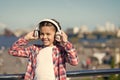 Girl child listen music outdoors with modern headphones. Kid little girl listen song headphones. Music account playlist