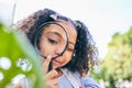 Girl child, magnifying glass and leaves in garden, backyard or park in science, study or outdoor. Young female kid, lens