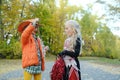 Girl child in an orange jacket and a cowboy hat shows her friend in a cheerleader costume her skeletons on a rope Royalty Free Stock Photo