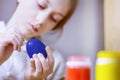 A girl child paints an egg with a brush for Easter Royalty Free Stock Photo