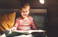 Girl child reads book in bed Royalty Free Stock Photo