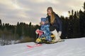 A girl with a child riding on a sledge