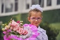 A girl child in school uniform with bows, glasses and a school bag on his back goes to the first class of the school on September Royalty Free Stock Photo