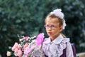 A girl child in school uniform with bows, glasses and a school bag on his back goes to the first class of the school on September Royalty Free Stock Photo