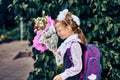 A girl child in school uniform with bows, glasses and a school bag on his back goes to the first class of the school on September Royalty Free Stock Photo