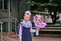 A girl child in school uniform with bows, glasses and a school bag on his back goes to the first class of the school on September Royalty Free Stock Photo