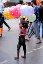 A girl child selling balloons in the street of Nasik, India.