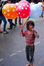 A girl child selling balloons in the street of Nasik, India.