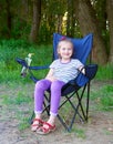 Girl child sit on chair in forest at family picnic