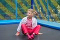 Girl child sitting on an outdoor trampoline