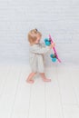 Girl, child on a skateboard on a white brick wall background