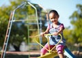 Girl child, smile and seesaw at park, school or outdoor in spring for playful games, adventure or freedom. Kid Royalty Free Stock Photo