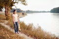 The girl child with toy bear walking along the path in the forest at sunset, beautiful river and landscape Royalty Free Stock Photo