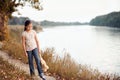 The girl child with toy bear walking along the path in the forest at sunset, beautiful river and landscape Royalty Free Stock Photo