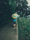 Girl child walking on street road under rain with rainbow umbrella Royalty Free Stock Photo