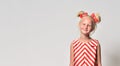 Girl child 7 years old in red striped clothes on a gray background in the studio