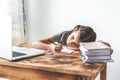 girl child 6 years old sitting at a desk in front of a laptop with notebook and pen, gets bored and wants to sleep. Royalty Free Stock Photo