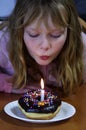 Girl with chocolate donut with sprinkles and birthday candle Royalty Free Stock Photo