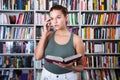 Girl chooses a book in the library Royalty Free Stock Photo