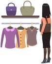 Girl chooses outfit in wardrobe at home or in boutique. Lady in dress chooses garment while shopping