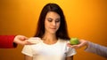 Girl choosing apple instead of donut, natural sugar and vitamin vs confectionery Royalty Free Stock Photo