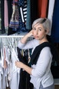 Girl choosing clothes in a dressing room with a black t-shirt and a white t-shirt undecided Royalty Free Stock Photo