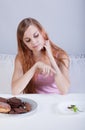 Girl choosing diet over sweets Royalty Free Stock Photo