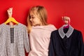 Child girl choosing clothes for school isolated on green background