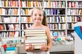 Girl chose a lot of books in the library Royalty Free Stock Photo