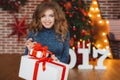 Girl with Christmas gift near beautiful dressed Christmas tree Royalty Free Stock Photo