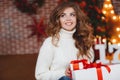 Girl with Christmas gift near beautiful dressed Christmas tree Royalty Free Stock Photo