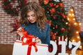 Girl with Christmas gift near beautiful dressed Christmas tree Royalty Free Stock Photo
