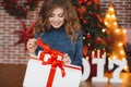 Girl with Christmas gift near beautiful dressed Christmas tree Royalty Free Stock Photo